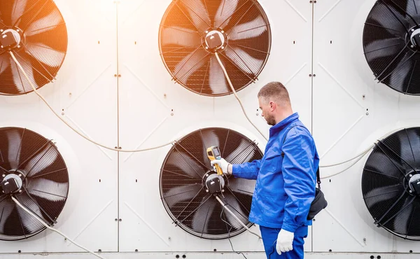 Teknisyen, yoğunlaştırma ünitesi ısı değiştiricisini kontrol etmek için termal görüntüleme kızılötesi termometresi kullanıyor.. — Stok fotoğraf