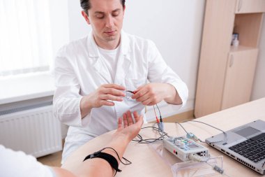 Tıbbi merkezde elektromiyografi kullanan hasta sinirleri test ediliyor.