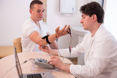 Tıbbi merkezde elektromiyografi kullanan hasta sinirleri test ediliyor.