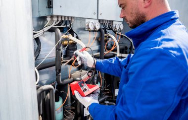 Elektronik ısı sensörlerini elektronik lehimleme demiriyle tamir eden teknisyen.