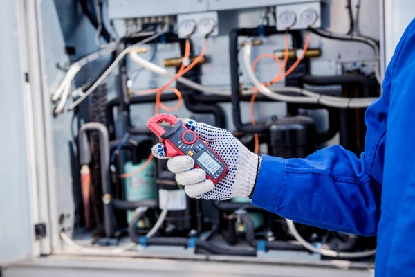 El técnico comprueba las líneas eléctricas del intercambiador de calor con abrazaderas de corriente —  Fotos de Stock