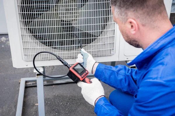 De technicus gebruikt een digitale camera om de verstopping van de warmtewisselaar te controleren — Stockfoto