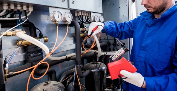 Der Techniker repariert elektronische Temperatursensoren mit einem elektronischen Lötkolben — Stockfoto