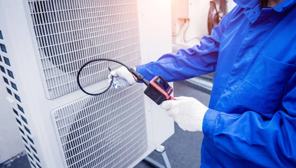 El técnico utiliza una cámara digital para comprobar la obstrucción del intercambiador de calor —  Fotos de Stock