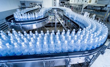 Modern bir içecek fabrikasında içme suyu şişeleriyle taşıma bandı..