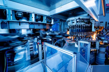 Modern içecek fabrikasında otomatik doldurma makinesi plastik PET şişelerine su doldurur.