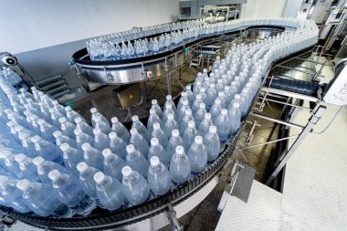 Modern bir içecek fabrikasında içme suyu şişeleriyle taşıma bandı..