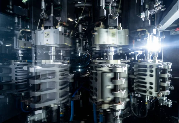 Máquina de enchimento automático derrama água em garrafas PET de plástico na moderna fábrica de bebidas. — Fotografia de Stock