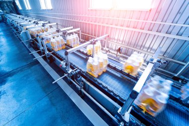 İçecek fabrikasında ambalaj hattı için modern bağlama ve taşıma makinesi.