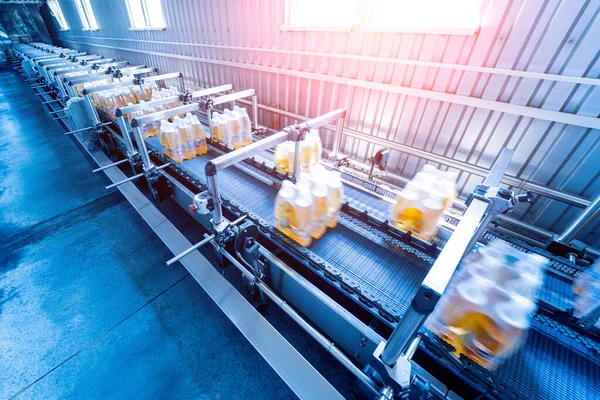 İçecek fabrikasında ambalaj hattı için modern bağlama ve taşıma makinesi.