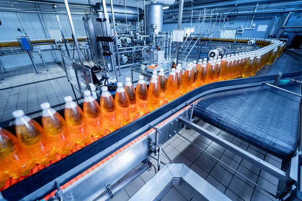 Modern bir içecek fabrikasında meyve suyu veya su için şişeli taşıyıcı bant — Stok fotoğraf