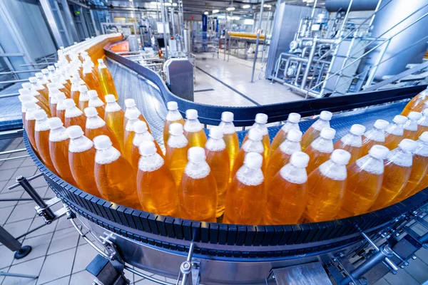 Cinta transportadora con botellas para zumo o agua en una moderna planta de bebidas — Foto de Stock