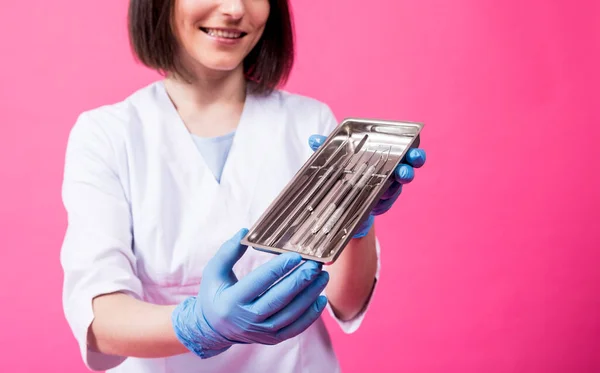 Kvinde tandlæge åbner en pakke af sterile tandinstrumenter - Stock-foto