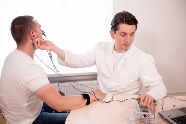 Tıbbi merkezde elektromiyografi kullanan hasta sinirleri test ediliyor.