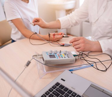 Tıbbi merkezde elektromiyografi kullanan hasta sinirleri test ediliyor.