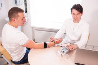 Tıbbi merkezde elektromiyografi kullanan hasta sinirleri test ediliyor.