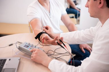 Tıbbi merkezde elektromiyografi kullanan hasta sinirleri test ediliyor.