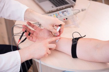Tıbbi merkezde elektromiyografi kullanan hasta sinirleri test ediliyor.