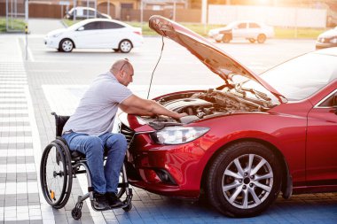 Tekerlekli sandalyedeki engelli adam, arabasını park yerinde kontrol et.