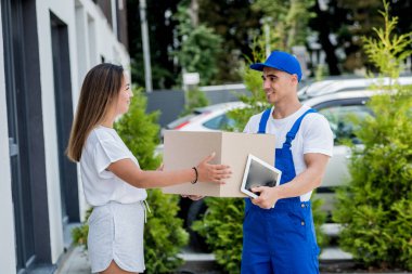 Genç kurye evde genç bir bayana mal getiriyor.