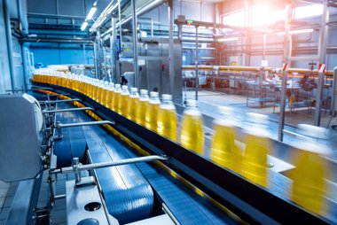 Modern bir içecek fabrikasında meyve suyu veya su için şişeli taşıyıcı bant