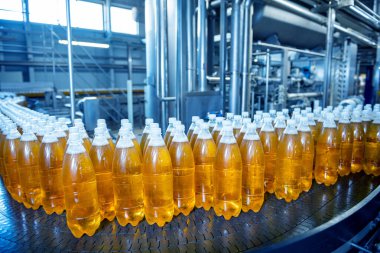 Modern bir içecek fabrikasında meyve suyu veya su için şişeli taşıyıcı bant