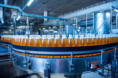 Modern bir içecek fabrikasında meyve suyu veya su için şişeli taşıyıcı bant