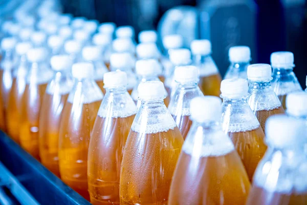 Конвеєрний пояс з пляшками для соку або води на сучасному заводі напоїв — стокове фото