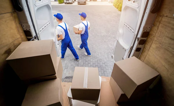 Twee verhuisbedrijf werknemers lossen dozen uit minibus — Stockfoto