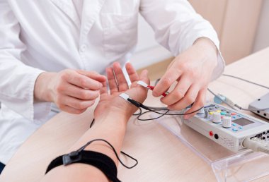 Tıbbi merkezde elektromiyografi kullanan hasta sinirleri test ediliyor.