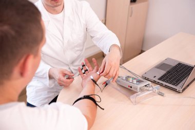 Tıbbi merkezde elektromiyografi kullanan hasta sinirleri test ediliyor.
