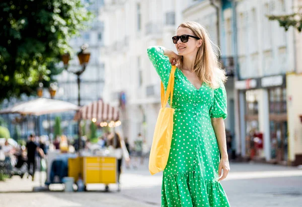 Mujer joven y hermosa con bolso ecológico de lino amarillo en el fondo de la ciudad. — Foto de Stock