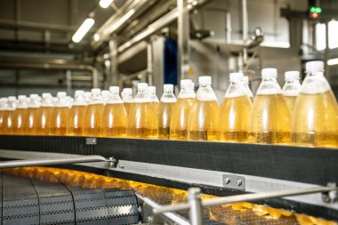 Modern bir içecek fabrikasında meyve suyu veya su için şişeli taşıyıcı bant