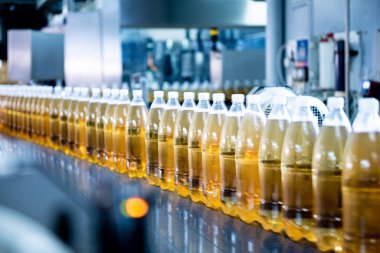 Modern bir içecek fabrikasında meyve suyu veya su için şişeli taşıyıcı bant