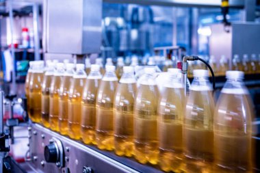 Modern bir içecek fabrikasında meyve suyu veya su için şişeli taşıyıcı bant