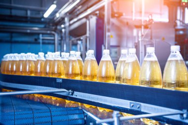 Modern bir içecek fabrikasında meyve suyu veya su için şişeli taşıyıcı bant