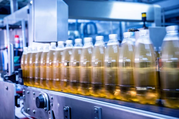 Cinta transportadora con botellas para zumo o agua en una moderna planta de bebidas — Foto de Stock