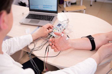 Tıbbi merkezde elektromiyografi kullanan hasta sinirleri test ediliyor.