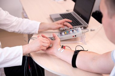 Tıbbi merkezde elektromiyografi kullanan hasta sinirleri test ediliyor.