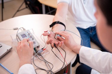 Tıbbi merkezde elektromiyografi kullanan hasta sinirleri test ediliyor.