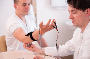 Tıbbi merkezde elektromiyografi kullanan hasta sinirleri test ediliyor.