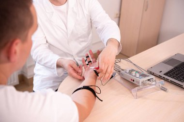Tıbbi merkezde elektromiyografi kullanan hasta sinirleri test ediliyor.