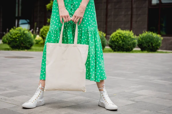 Mujer joven y hermosa con bolsa ecológica de lino en el fondo de la ciudad. — Foto de Stock