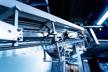 Modern içecek fabrikasında otomatik doldurma makinesi plastik PET şişelerine su doldurur.