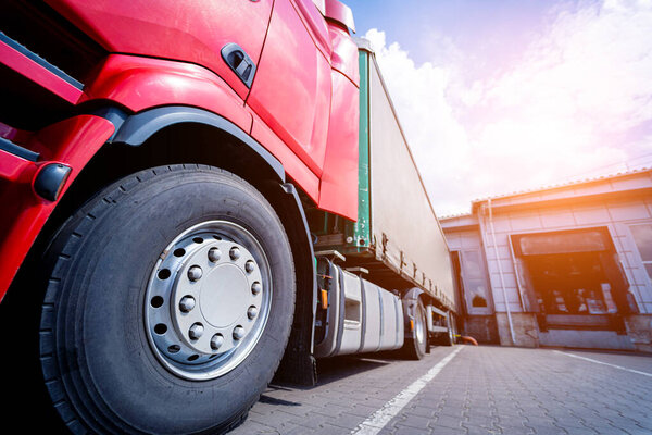 Large trucks near warehouse against blue sky background