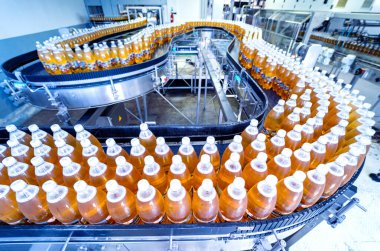 Modern bir içecek fabrikasında meyve suyu veya su için şişeli taşıyıcı bant