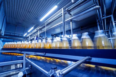 Modern bir içecek fabrikasında meyve suyu veya su için şişeli taşıyıcı bant