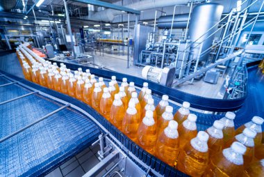 Modern bir içecek fabrikasında meyve suyu veya su için şişeli taşıyıcı bant