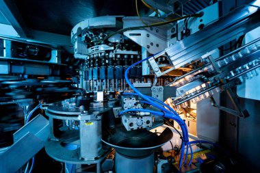 Modern içecek fabrikasında otomatik doldurma makinesi plastik PET şişelerine su doldurur.