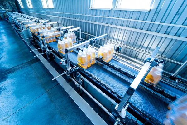 Modern strapping and transporting machine for packaging line at beverage plant.